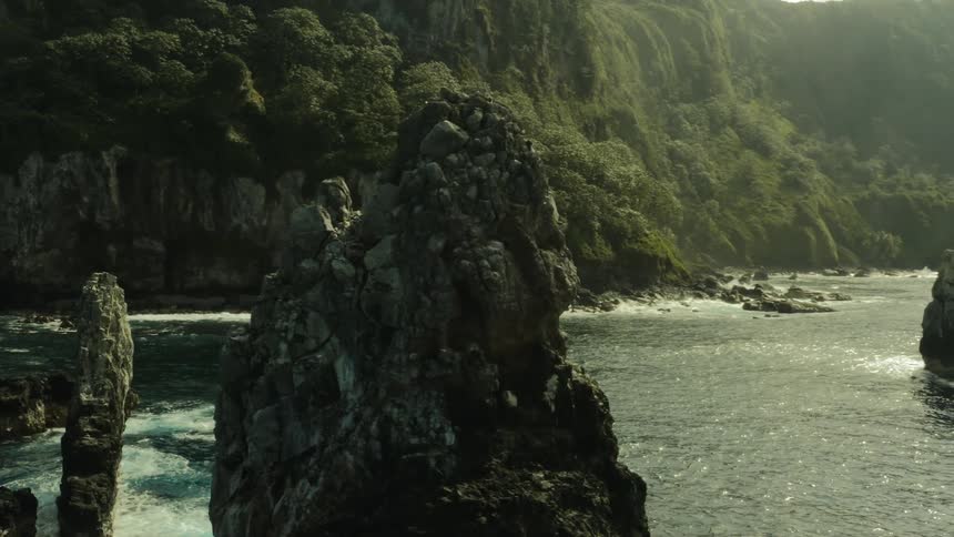 Aerial of large rock formations off the coast in a tropical area