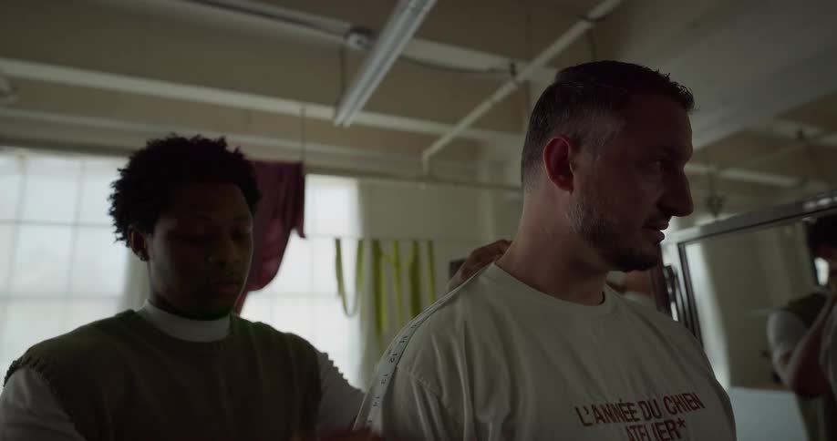 Male tailor measures man with a measuring tape