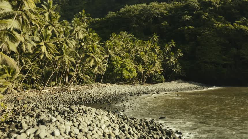 Aerial panorama of a beautiful beach with seaside rocks and a tropical forest around