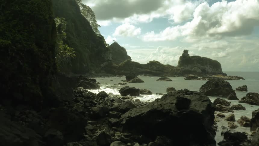 A tropical coastline with rock formations and vegetation