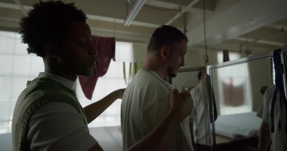 A tailor measures a male customer