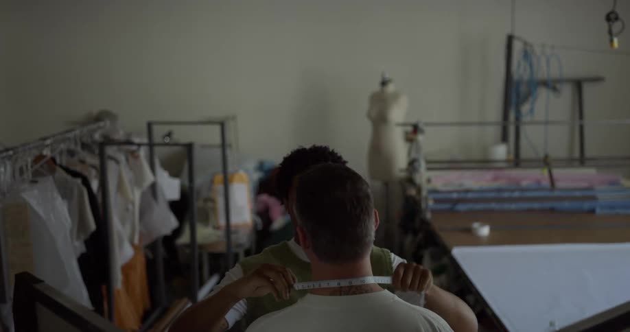 A tailor measures a client for a custom fit