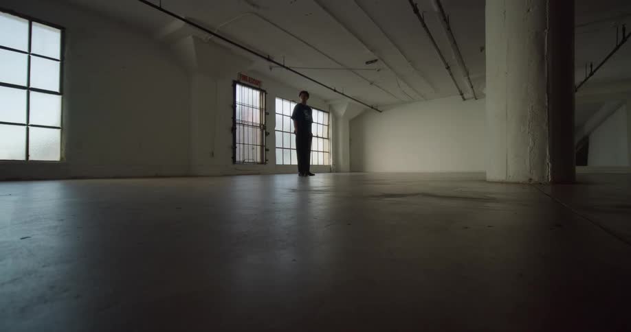 A man walks around in a large empty room