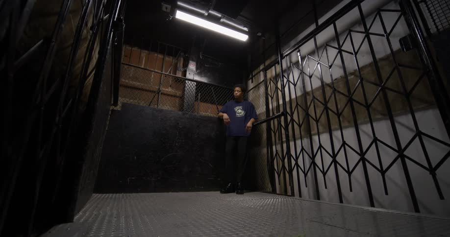Man in the corner of an elevator that is going up