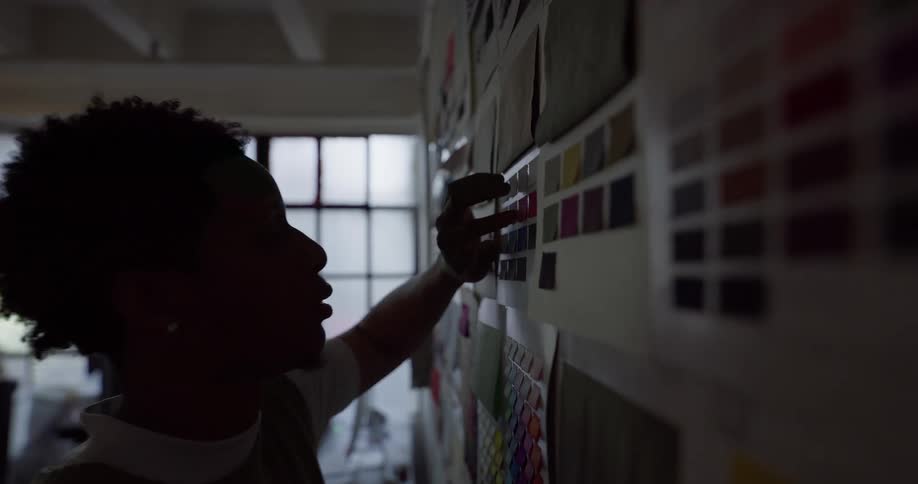 Man in an office room looking at documents that are on the wall