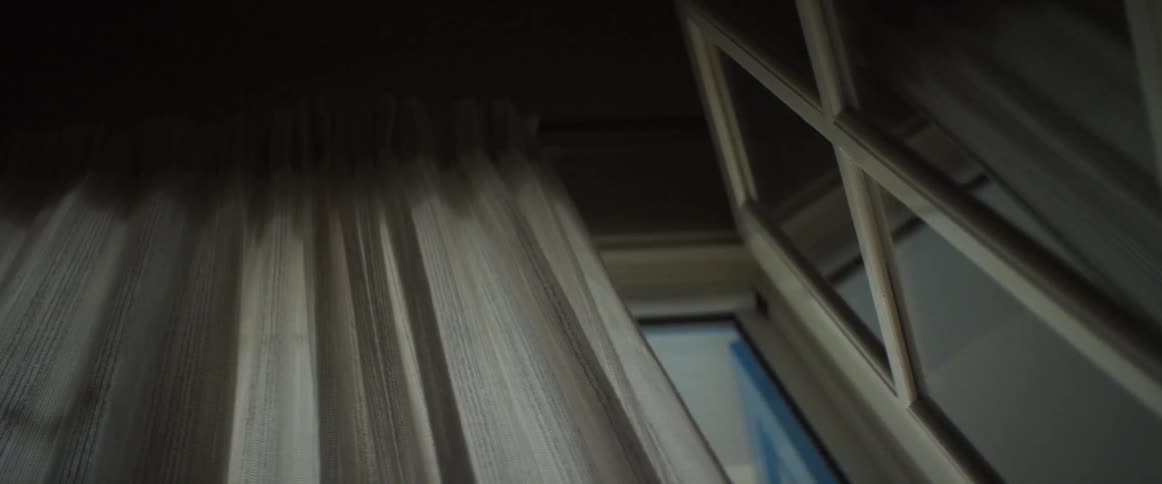 Curtains blowing in the breeze by a window