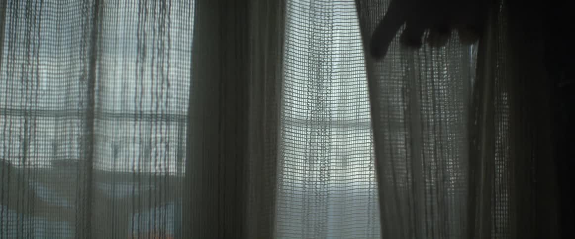 A person feeling some curtains