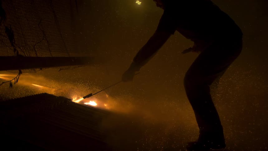 A man lights fireworks from a board at night