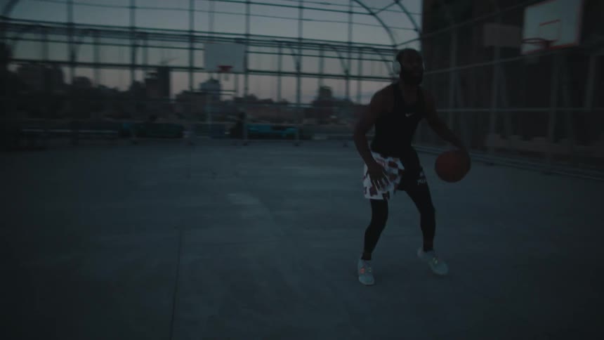 Man on a court practicing basketball