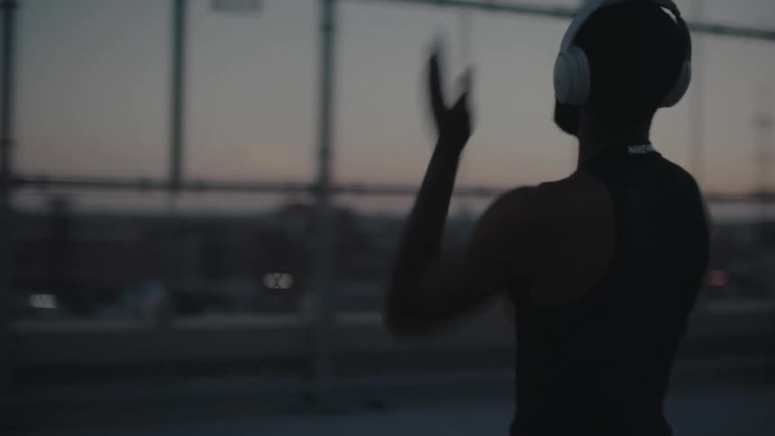A black man shoots a basketball in an enclosed court