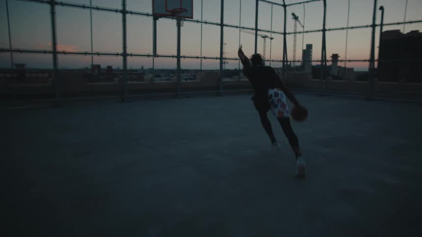 A black man does a lay up on a court