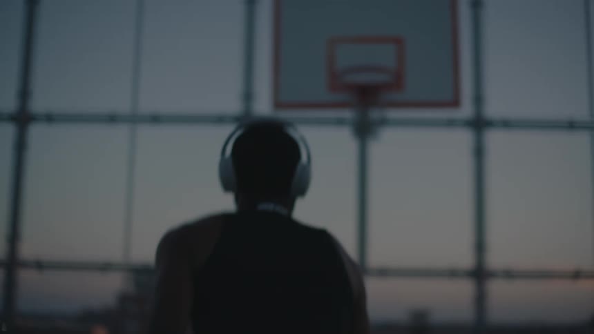 Man on a basketball court training in the late afternoon