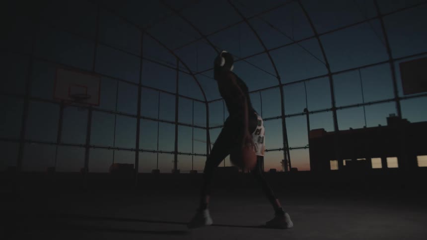 A black man dribbles and moves on a basketball court