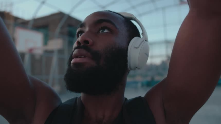 Portrait of a concentrated man with headphones shooting a basketball