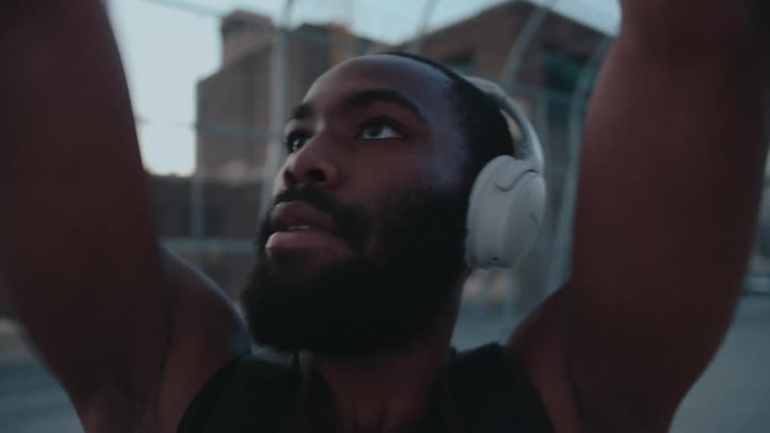 Portrait of a man with headphones shooting a ball on a basketball court