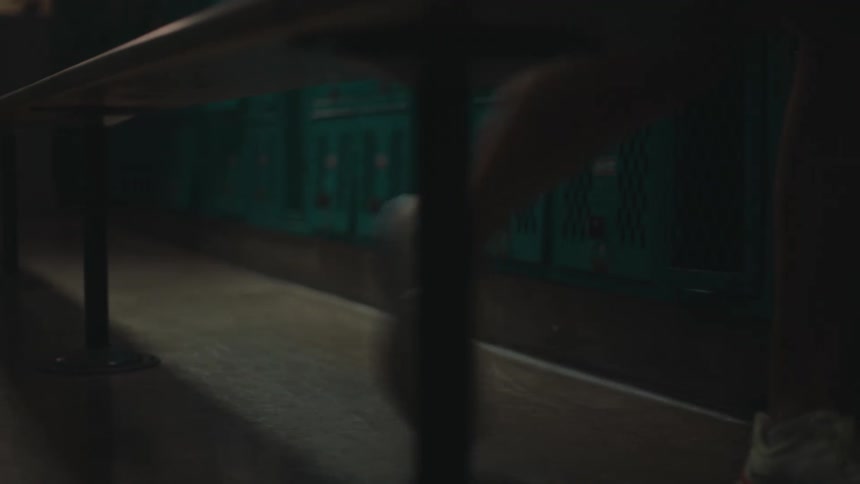 Feet of a person in white sneakers walking in a hallway