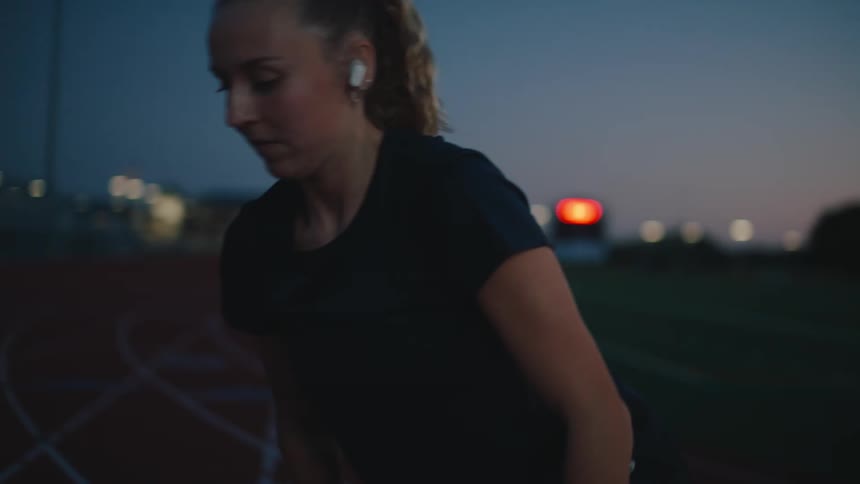 A young woman rides across a track