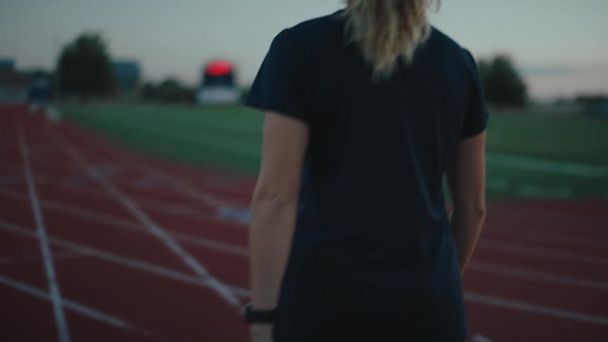 A white woman walks on a track