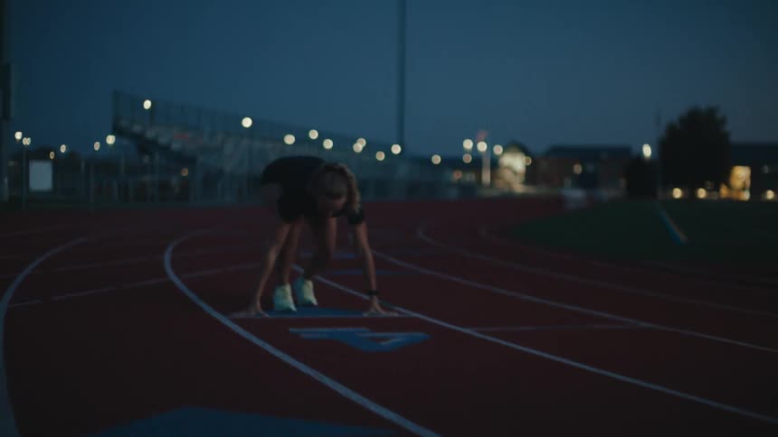 A young woman runs on a track