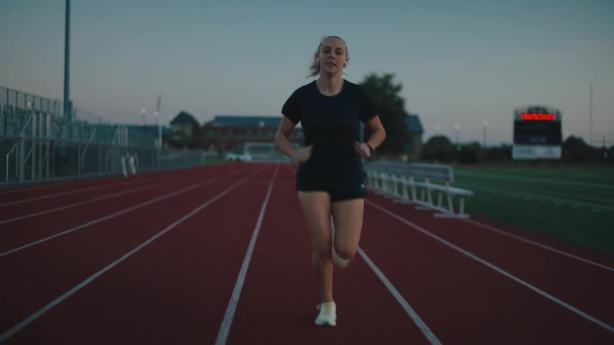 A woman is jogging on the track