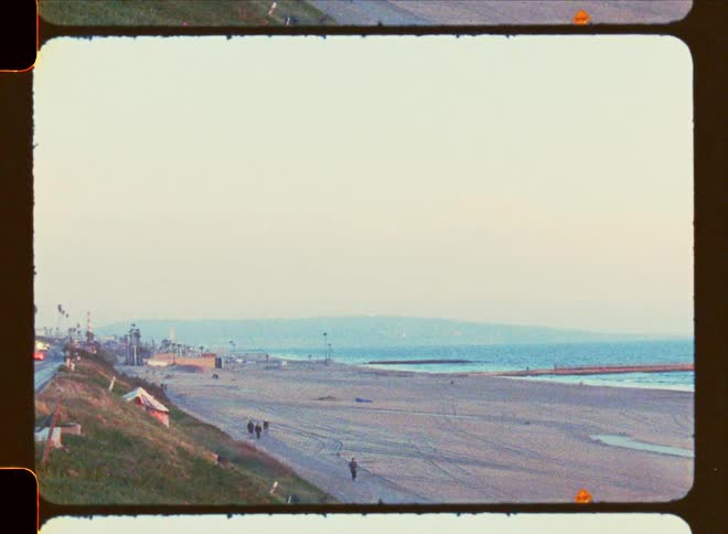 Landscape of a beach with some people walking on a morning