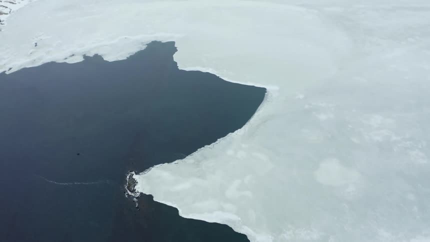 An ice cap partly covering a body of water