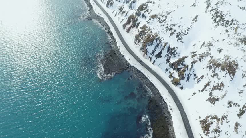 A car drives down the coastal road