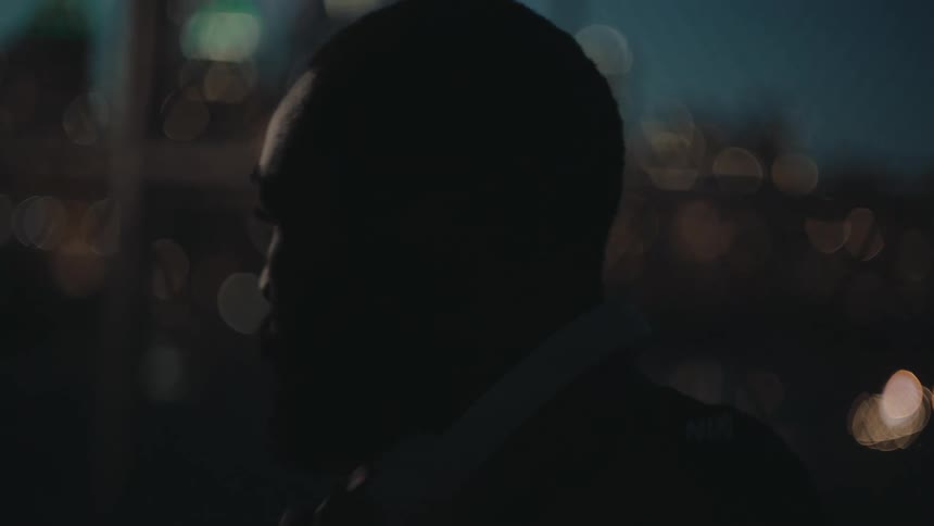 Bearded man takes off white headphones and walks away on a basketball court