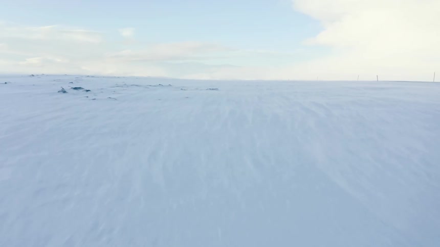 Wind blows on the long icy landscape