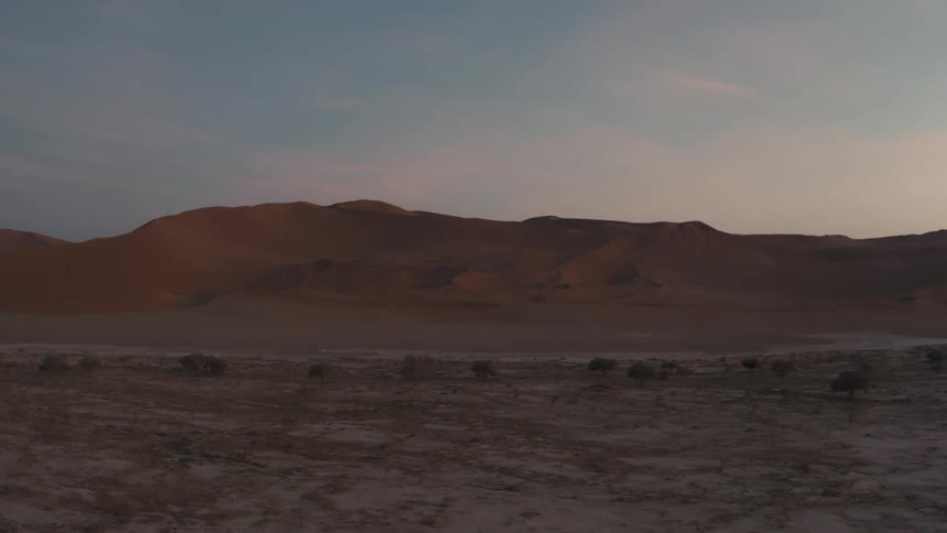 A desert region with large elevations of sand in the background