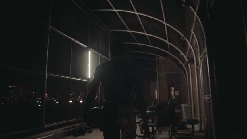 Man with his back walking with a basketball