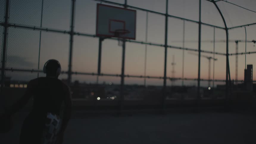 Man running and throwing a ball into the basketball hoop