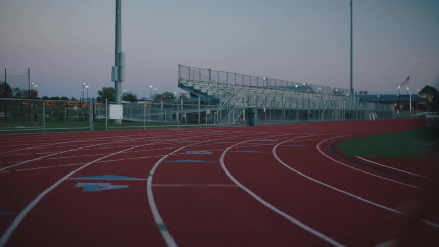 Woman running at high speed down an athletics track