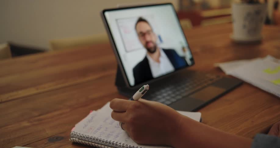 A virtual meeting on a laptop with some key notes jotting on the table
