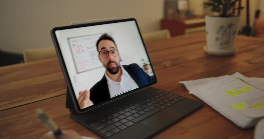 Mother holds her baby while on video call during remote work
