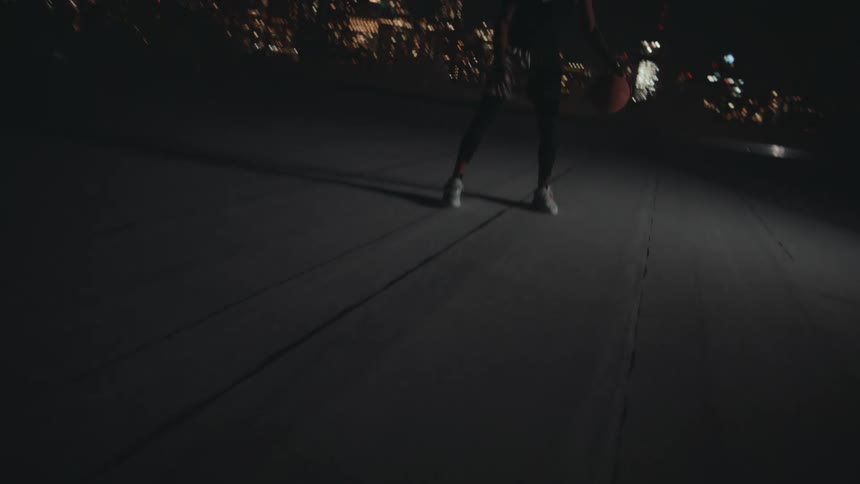 A black man dribbles a basketball