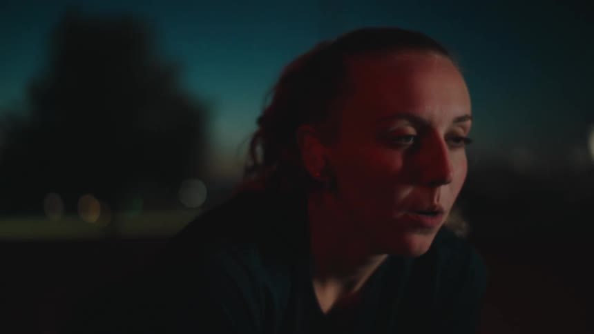 A sad woman hugging herself about to sing to herself at night