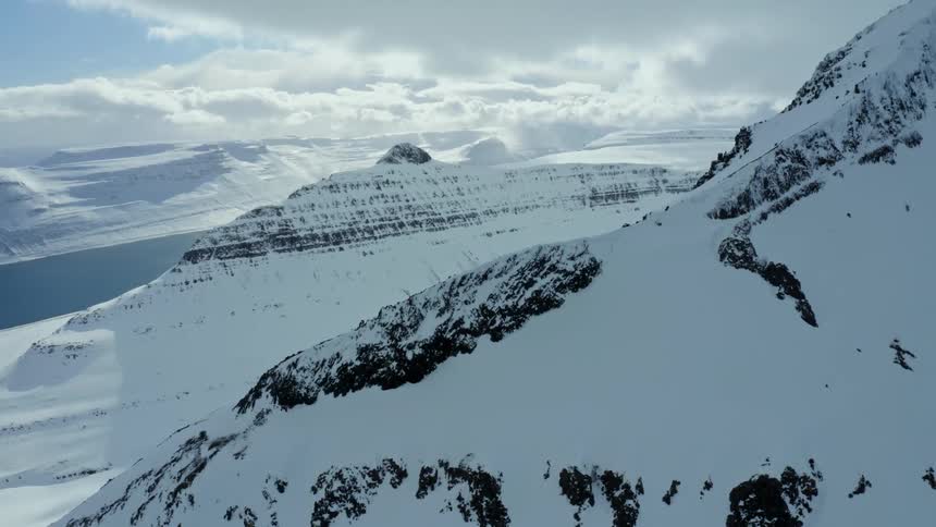 A range of enormous snowcapped mountains in the arctic