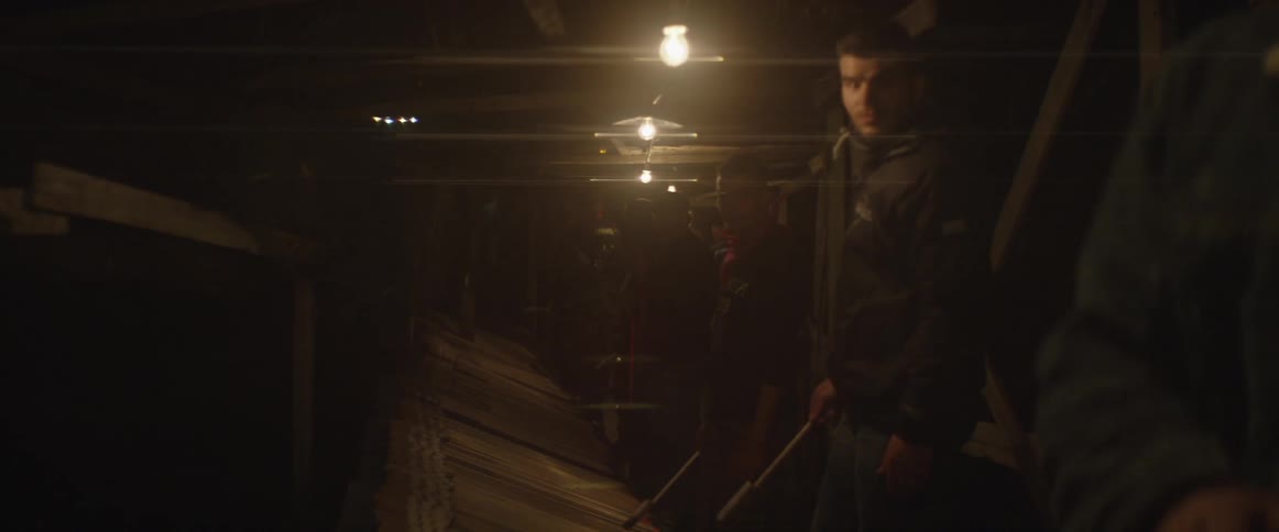 A man standing with a few friends looks around as he waits