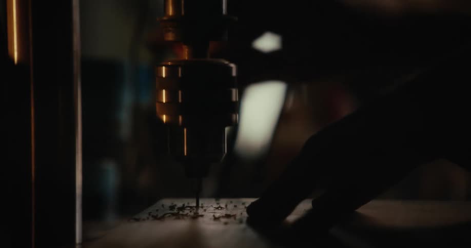 A man drills through a piece of wood