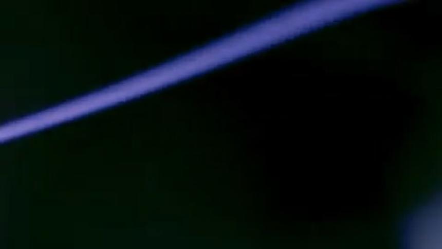 Blue bolt moves through interior of plasma ball in a dark area