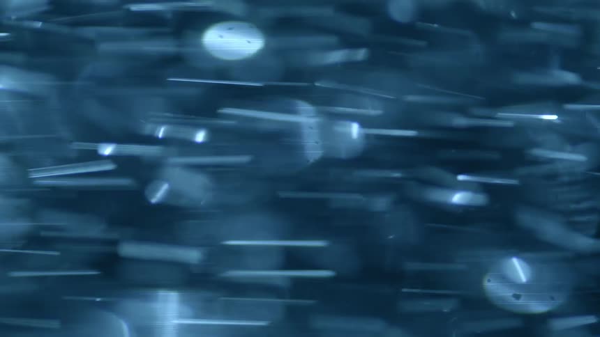 Large number of reflective disks swirl through an area