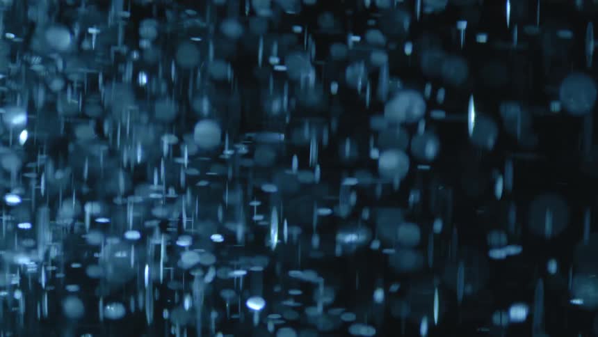 Abstract moving water with particles against a black background