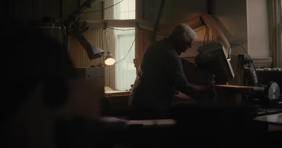 A man is sanding wood in the shop