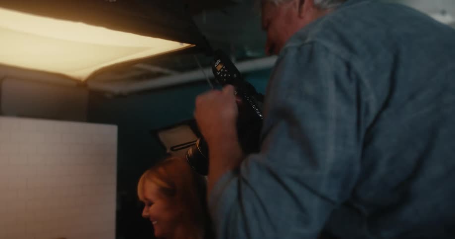 Man using a professional camera and photographing a scene with a woman by his side