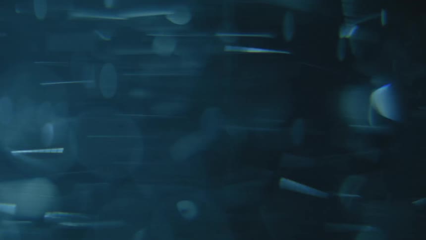 Reflective disks form a mass spinning through a dark area