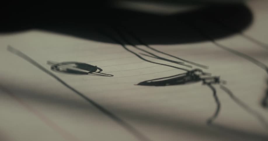 A person draws a planet and rocket ship on paper