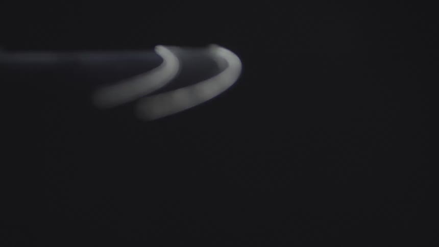 A spinning white light circling against a dark bacground