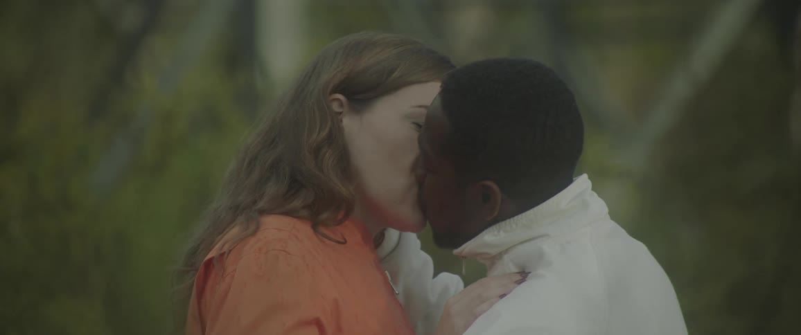 Couple kissing romantically and a wooded environment