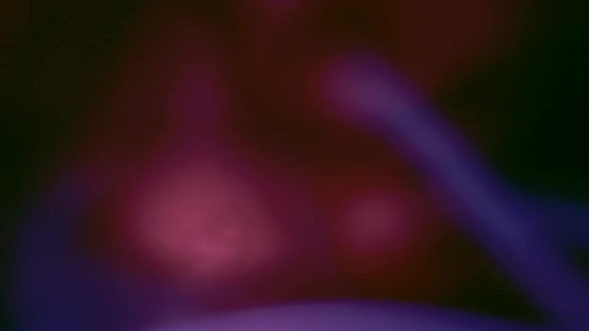 Close up of spinning purple plasma beams against a dark background